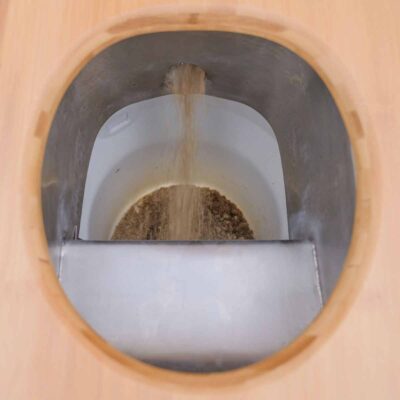 Detailansicht des Einstreusystems in der Libre Trockentoilette mit fallender Einstreu in Auffangbehälter unter Peepot-Trennsystem.