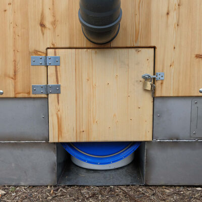 Serviceklappe für Feststoffbehäter aus Holz mit Vorhängeschloss an der Libre Trockentoilette.