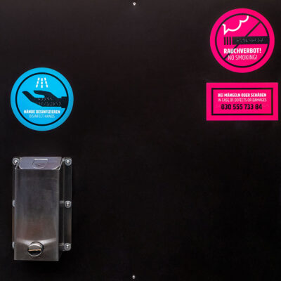 Blaue und pinke Nutzungshinweise in der öffentlichen Trocken- und Trenntoilette Libre.