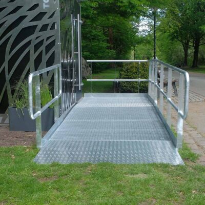 Rampe mit rutschfester Oberfläche und seitlichen Handläufen vor der rollstuhlgerechten Libre-DIN-Kabine.
