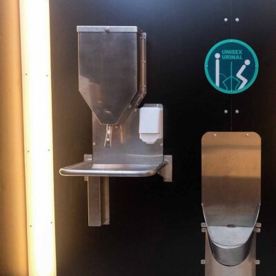 Frontansicht des Unisexurinals und Handwaschstation in der Libre-DIN. Kabine