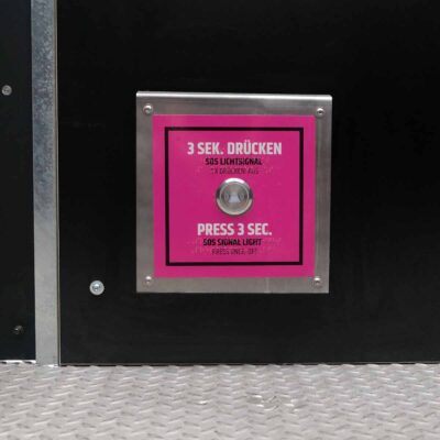 Detailansicht des SOS-Notfallknopfs mit pinkem Hinweisfeld in der rollstuhlgerechten Libre-DIN Trockentoilette.
