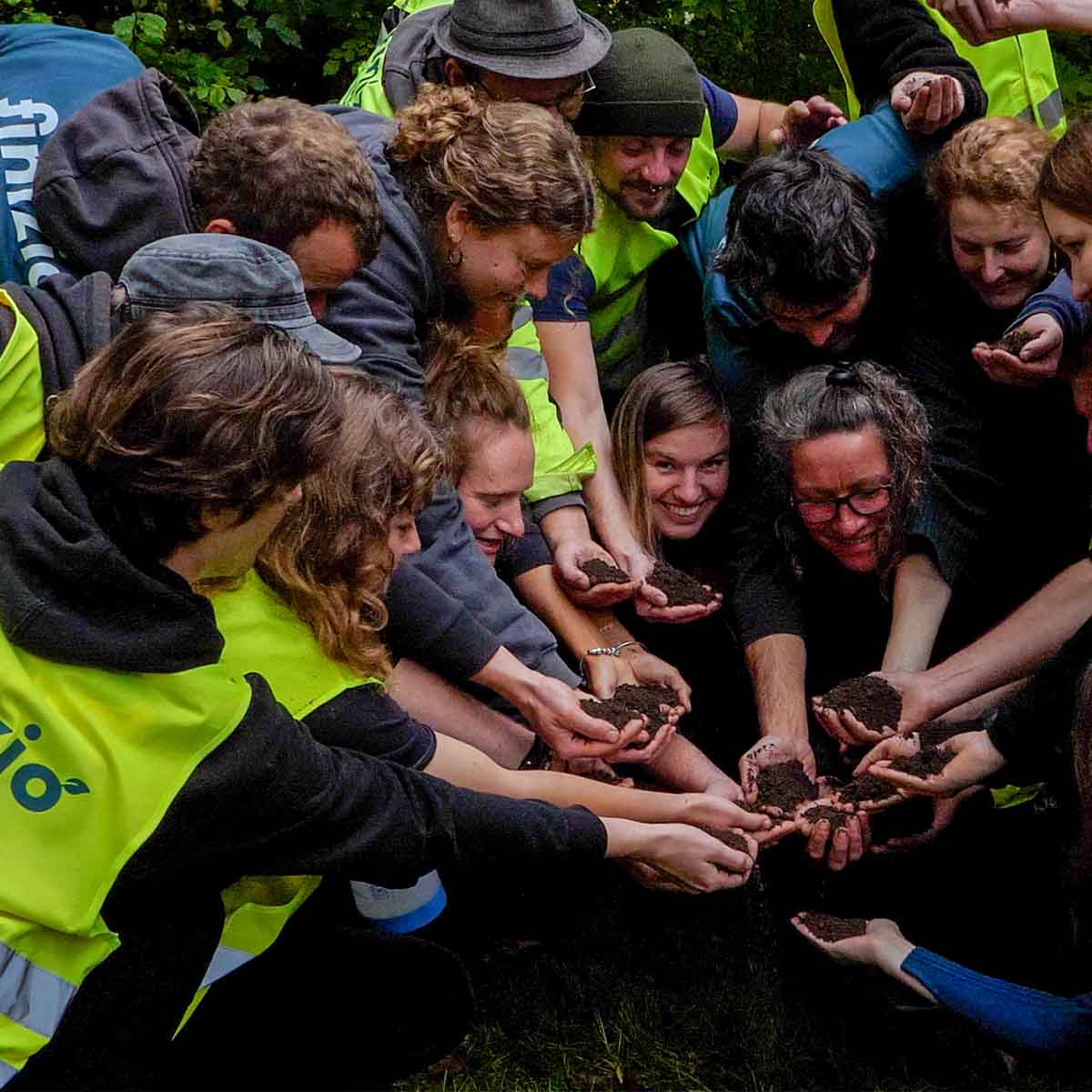 Die Mitarbeiter von Finizio reichen mit ihren Händen ihren Humusdünger aus Inhalten Trockentoiletten