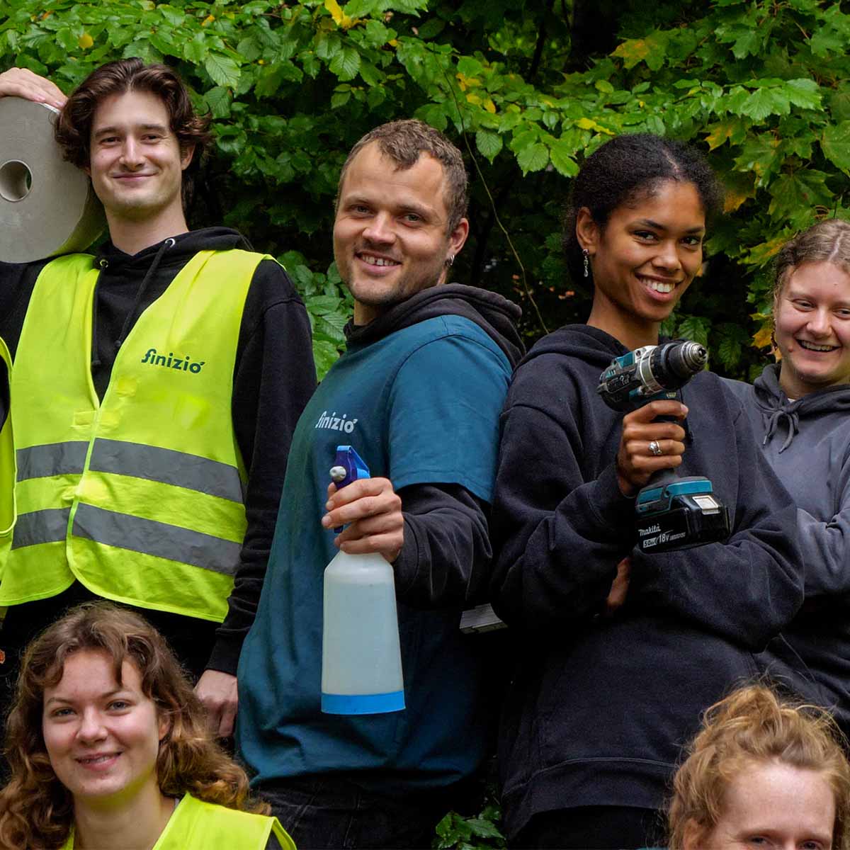 Mitarbeiter von Finizio im Einsatz mit Akkuschrauber, Putzzeug und Arbeitskleidung.